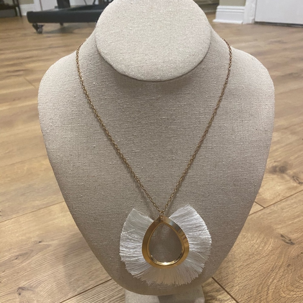 Gold necklace with white tassel loop